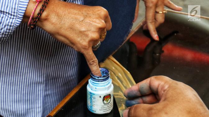 Warga memasukkan jarinya ke dalam botol berisi tinta saat simulasi pemungutan dan pencoblosan surat suara Pemilu 2019 di Taman Suropati, Jakarta, Rabu (10/4). Simulasi dilakukan untuk meminimalisir kesalahan dan kekurangan saat pencoblosan pemilu pada 17 April nanti. (Liputan6.com/Johan Tallo)