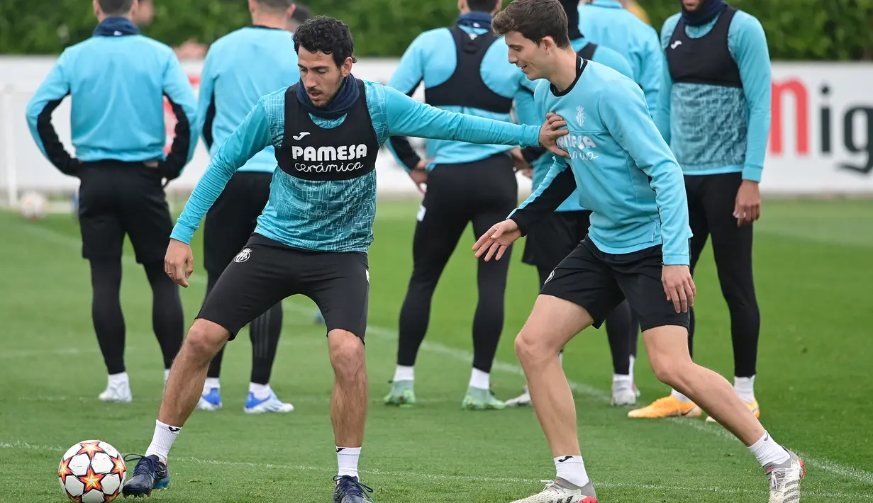 Gelandang Villarreal Dani Parejo (kiri) bersaing dengan Pau Francisco selama sesi latihan sebelum leg kedua babak perempat final Liga Champions di Ciudad deportiva Villarreal di Vila-Real, Senin (11/4/2022). Villarreal akan kembali bertemu Bayern Munchen pada Rabu 13 April 2022. (JOSE JORDAN/AFP)