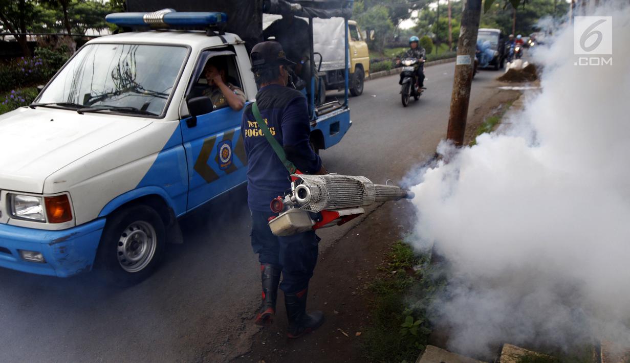 Petugas melakukan pengasapan (fogging) untuk memutus siklus hidup nyamuk aedes aegypti di Jalan Delima Raya, Jakarta Barat, Selasa (30/4/2019). Pengasapan itu untuk mencegah penyebaran wabah penyakit Demam Berdarah Dengue (DBD) saat musim hujan mulai terjadi di Jakarta. (Liputan6.com/Johan Tallo)