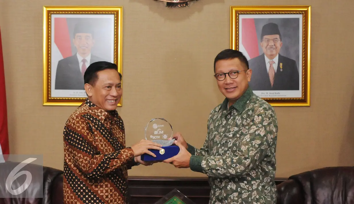 Dirut Indosiar, Imam Sudjarwo (kiri) menyerahkan cenderamata kepada Menag Lukman Hakim Saifuddin usai melakukan audiensi di Jakarta, Jumat (27/5). Pertemuan membahas sejumlah hal jelang bulan suci Ramadan. (Liputan6.com/Helmi Fithriansyah)