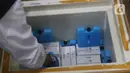 Petugas memasukkan vaksin COVID-19 Sinovac ke dalam lemari pendingin saat tiba di Gudang UPTD Farmasi Kabupaten Bekasi, Tambun, Jawa Barat, Rabu (27/1/2021). Pengiriman tahap pertama sebanyak 12.000 dosis dikemas dalam 300 dus berukuran kecil di tujuh kotak pendingin. (Liputan6.com/Herman Zakharia)