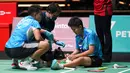 Siti Fadia Silva Ramadhanti (kanan) menerima perawatan medis disaksikan Apriyani Rahayu saat memutuskan mundur melawan China Chen Qing Chen dan Jia Yi Fan pada pertandingan semifinal ganda putri turnamen bulu tangkis Malaysia Open 2023 di Bukit Jalil Axiata Arena, Kuala Lumpur, Malaysia, Sabtu (14/1/2023). Apriyani Rahayu/Siti Fadia Silva Ramadhanti gagal mengamankan tiket final Malaysia Open 2023 setelah sepakat untuk mengakhiri laga lebih dulu karena Fadia mengalami cedera. (AP Photo/Kien Huo)
