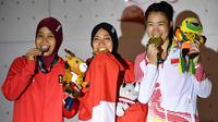 Peraih medali emas Indonesia Susanti Rahayu Aries (tengah), medali perak Indonesia Puji Lestari dan medali perunggu China, He Cuilian berpose pada upacara medali olahraga panjat tebing wanita Asian Games 2018 di Palembang (23/8). (AFP PHOTO / Adek Berry