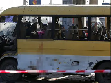 Petugas keamanan dan pemadam kebakaran saat mengecek kondisi minibus yang terkena serangan bunuh diri di Kabul, Afghanistan, Senin (20/6). Sebanyak 14 orang tewas akibat serangan ini. (REUTERS / Omar Sobhani)