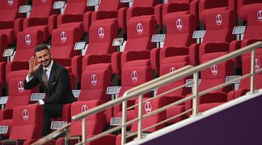 Mantan pemain dan kapten Inggris David Beckham duduk di tribun sebelum dimulainya pertandingan grup B Piala Dunia antara Inggris dan Iran di Stadion Internasional Khalifa, di Doha, Qatar, Senin (21/11/2022). David Beckham diketahui saat ini bekerja sebagai duta Piala Dunia 2022 di Qatar dengan kontrak senilai £10 juta. (AFP/Paul Ellis)
