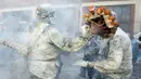 Orang-orang yang mengenakan pakaian militer ikut serta dalam perang makanan "Els Enfarinats" di Kota Ibi, Spanyol, 28 Desember 2022. Dalam festival musim dingin ini para peserta mengenakan pakaian militer dan mementaskan tiruan kudeta di luar balai kota. (JAIME REINA/AFP)