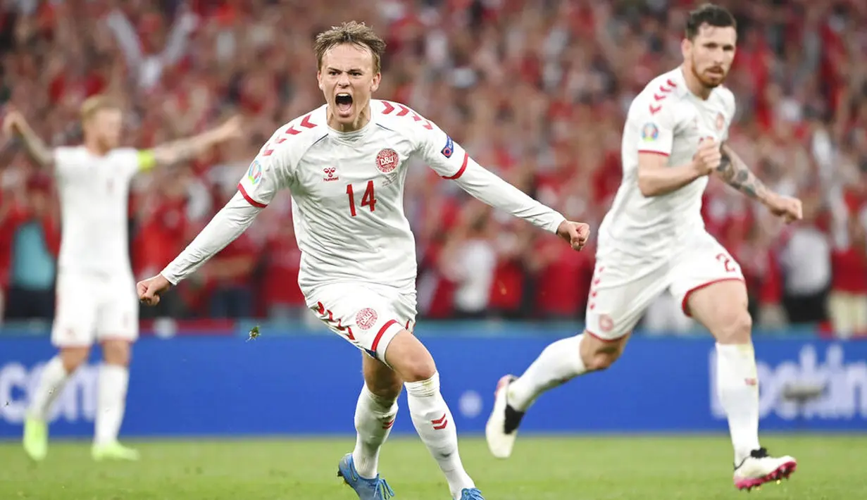 Pemain muda Denmark, Mikkel Damsgaard, merayakan gol yang dicetaknya ke gawang Rusia. Ia sukses mengukir rekor sebagai pencetak gol termuda untuk Denmark di Euro dengan usai 20 tahun 353 hari. (Jonathan Nackstrand/Pool via AP)