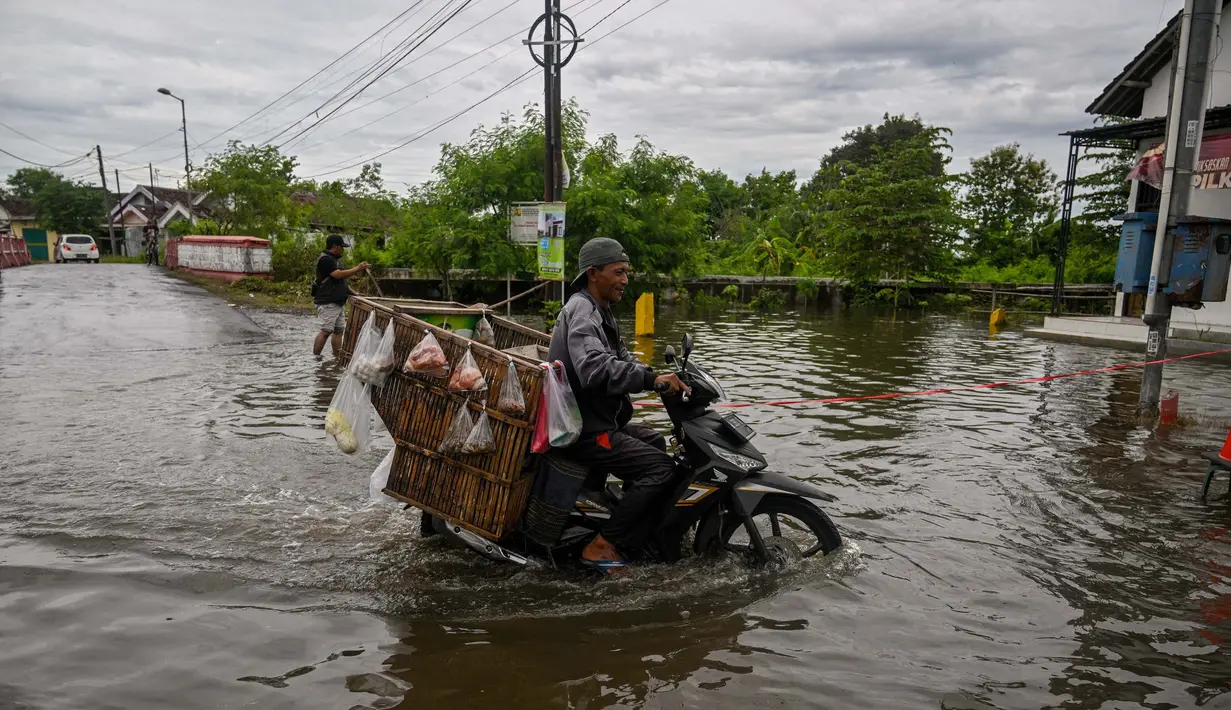 Ketinggian genangan air di wilayah mencapai lutut orang dewasa. (Juni KRISWANTO/AFP)