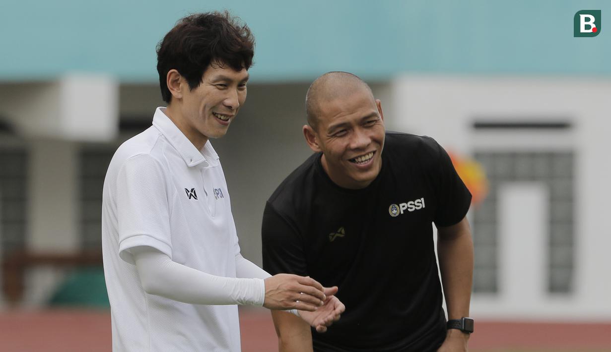 Asisten pelatih Timnas Indonesia, Gong Oh-kyun, berbincang dengan Nova Arianto saat sesi latihan di Stadion Wibawa Mukti, Cikarang, Senin (13/1/2020). Gong Oh-kyun dinyatakan postif terpapar virus corona. (Bola.com/M Iqbal Ichsan)