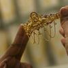Seorang pelanggan memegang perhiasan emas selama festival Hindu 'Akshaya Tritiya', hari keberuntungan dalam kalender Hindu untuk membeli barang-barang berharga, di ruang pamer perhiasan di Chennai, India, Selasa (3/5/2022). Membeli emas adalah kegiatan yang populer di Akshaya Tritiya, karena ini adalah simbol utama kekayaan dan kemakmuran. (Arun SANKAR / AFP)