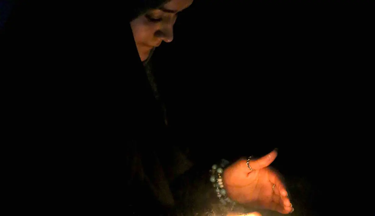 Seorang peziarah menyalakan lilin di luar kuil Imam al-Mahdi selama upacara Shaabaniya memperingati kelahiran Imam di kota Karbala, Irak tengah, (2/5). Peringatan ini datang dua minggu sebelum dimulainya bulan suci Ramadan. (AFP Photo/Mohammad Sawaf)