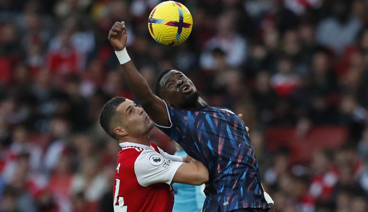Bek Nottingham Forest, Serge Aurier (kanan) berebut bola dengan gelandang Arsenal, Granit Xhaka pada laga Liga Inggris 2022/2023 di Emirates Stadium, London (30/10/2022). Pemain asal Pantai Gading ini didatangkan Nottingham Forest pada awal musim 2022/2023 saat berstatus tanpa klub setelah sebelumnya membela Villarreal. Ia dikontrak hanya setahun hingga Juni 2023. Di Liga Inggris 2022/2023 ia telah bermain 15 kali dengan torehan 1 gol. (AFP/Ian Kington)