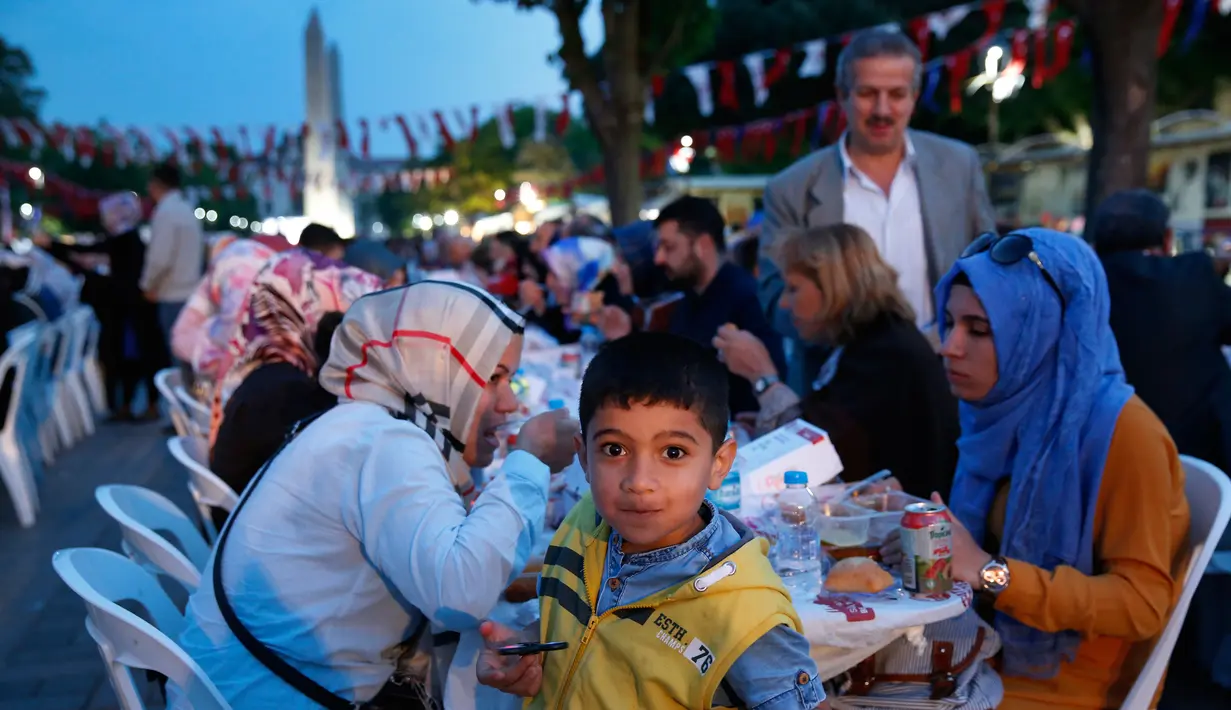 Sejumlah orang berbuka puasa di distrik Sultanahmet, Istanbul, Turki, Sabtu (27/5). Kawasan ini senantiasa ramai saat waktu berbuka di bulan Ramadan. AP Photo / Lefteris Pitarakis)