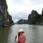 Wisatawan domestik berpose untuk foto di atas kapal di tengah Ha Long Bay, Quang Ninh, Vietnam, (16/5/2020). Seiring dengan meredanya virus corona, Ha Long Bay kawasan yang menjadi situs warisan dunia UNESCO kembali didatangi ratusan wisatawan. (AFP/Manan Vatsyayana)