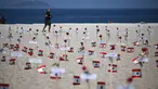 Seorang pria berjalan melewati 245 mawar yang ditempatkan oleh LSM Rio da Paz beserta nama korban dan bendera Lebanon untuk memperingati 3 tahun sejak ledakan Beirut 2020 di Pantai Copacabana, Rio de Janeiro, Brasil, diambil pada 4 Agustus 2023. (AFP/Carl De Souza)
