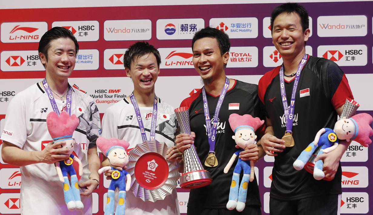 Ganda putra Indonesia  Mohammad Ahsan/Hendra Setiawan berpose dengan Hiroyuki Endo/Yuta Watanabe dari Jepang usai meraih juara BWF World Tour Finals 2019 di Tianhe Gymnasium, Guangzhou (15/12/2019).  Ahsan/Hendra menang  24-22, 21-19.  (AP Photo/Andy Wong)