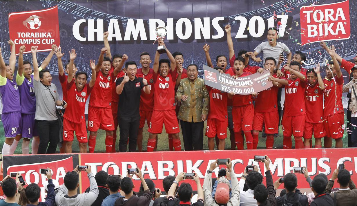 Pemain Universitas Muhammadiyah Malang (UMM) melakukan selebrasi di atas podium usai menjuarai Torabika Campus Cup 2017 di Stadion UM, Malang, Kamis, (02/11/2017). UMM menang 2-0 atas UM. (Bola.com/M Iqbal Ichsan)
