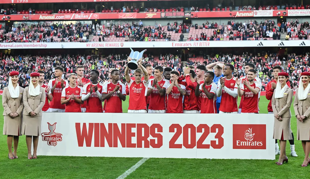 Gelandang Arsenal, Martin Odegaard (tengah) mengangkat trofi setelah memenangkan pertandingan sepak bola persahabatan pramusim untuk final Piala Emirates antara Arsenal dan Monaco di Stadion Emirates di London utara pada 2 Agustus 2023.(AFP/Glyn Kirk)