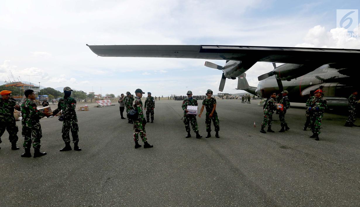 Prajurit TNI mendistribusikan bantuan logistik yang tiba di Bandara Mutiara Sis Al-Jufri, Palu, Sulawesi Tengah, Minggu (7/10). Tentara AS membantu mendistribusikan dari landasan menuju bandara. (Liputan6.com/Fery Pradolo)