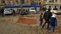 Warga berjalan melewati genangan darah dan air saat memeriksa ledakan di Kota Benghazi, Libya, Rabu (24/1). Juru bicara rumah sakit mengatakan jumlah korban tewas menyusul serangan bom mobil ganda ini meningkat menjadi 34 orang. (AFP PHOTO/Abdullah DOMA)