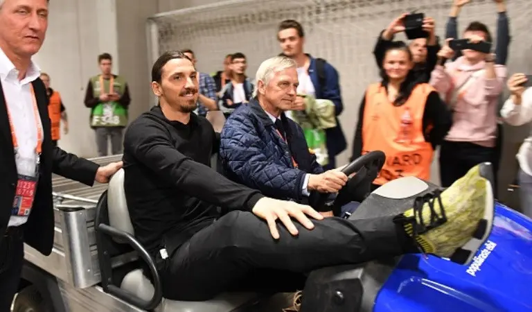 Zlatan Ibrahimovic diantar menggunakan golf buggy dari sisi luar menuju sisi dalam Friends Arena. (AFP/Janek Skarzynski)