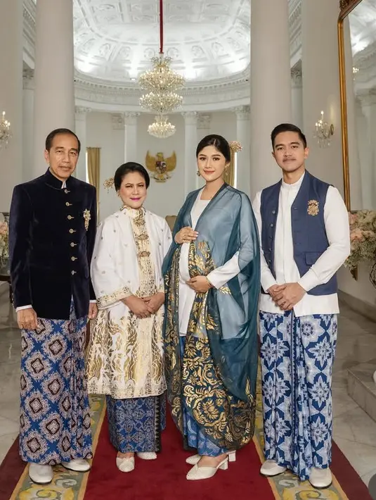 Jokowi tampil mengenakan beskap hitam berbahan velvet dengan kancing emas dan bros keemasan dipadukan bawahan kain batik biru. Sedangkan, Iriana mengenakan baju kurung putih kerah tinggi dengan motif keemasan dipadukan tuga bros dan bawahan kain batik biru.  [@riomotret]
