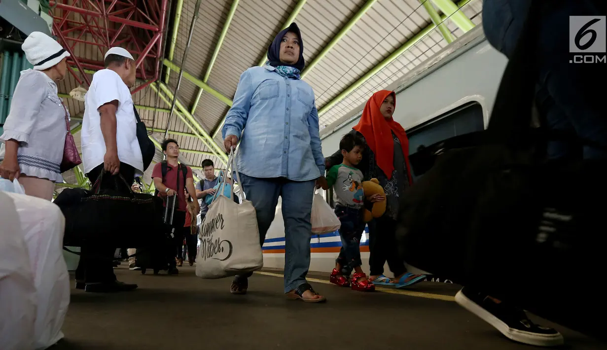 Sejumlah penumpang membawa barang bawaannya usai menaiki kereta di Stasiun Gambir, Jakarta, Rabu (29/11). (Liputan6.com/JohanTallo)