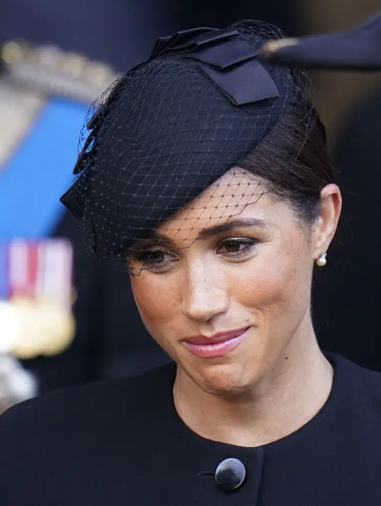 Ekspresi Meghan Markle usai mengikuti prosesi persemayaman Ratu Elizabeth II di Westminster Hall di London (14/9/2022). Meghan Markle tampil mengenakan sepasang anting-anting berlian dan mutiara. (AFP/Pool/Danny Lawson)