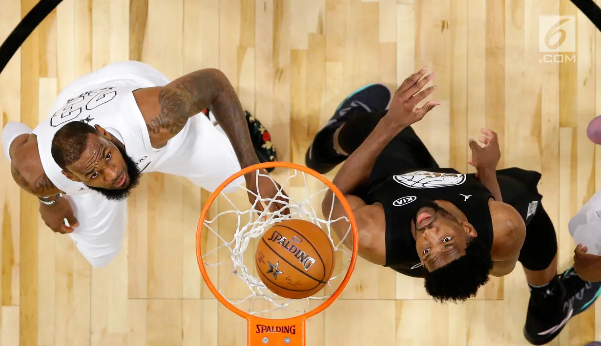 Pemain tim LeBron James, LeBron James (kiri) berebut bola dengan pemain Stephen, Joel Embiid (kanan) saat pertandingan basket NBA All Star di Los Angeles, AS, Minggu (18/2). LeBron mencetak 29 poin, 10 rebound, dan 8 assist. (Mike Nelson/Pool via AP)