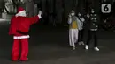 Pria berkostum Sinterklas menyapa pejalan kaki saat membagikan kopi gratis kepada warga di kawasan Jalan Jenderal Sudirman, Jakarta, Sabtu (19/12/2020). Pembagian kopi tersebut bertujuan untuk menyambut perayaan Natal 2020. (Liputan6.com/Johan Tallo)
