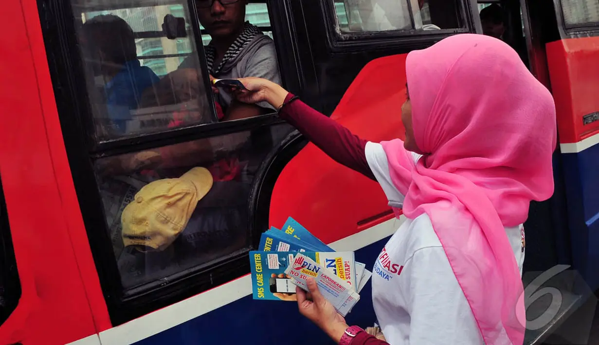 Sejumlah orang membagikan stiker di kawasan Bundaran HI, Jakarta, Selasa (12/9/2014). (Liputan6.com/Johan Tallo)