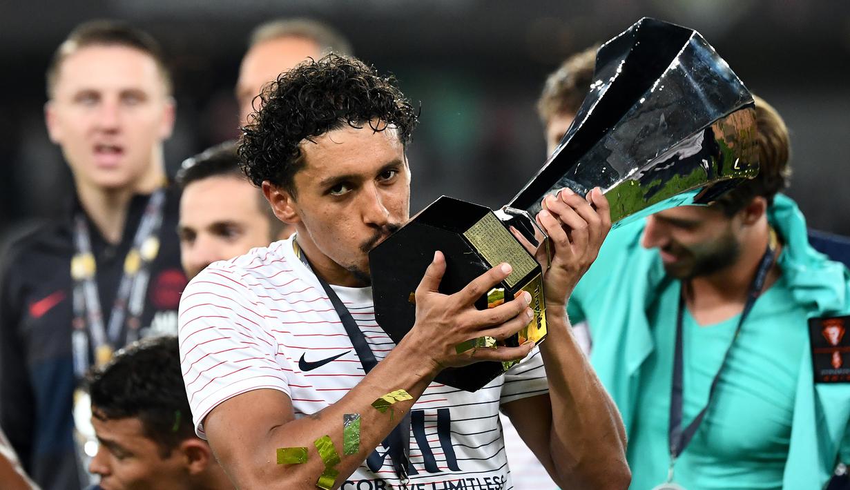 Bek PSG, Marquinhos, mencium piala saat merayakan gelar juara Piala Super Prancis usai mengalahkan Rennes di Stadion Shenzhen, China, Sabtu (3/8). PSG menang 2-1 atas Rennes. (AFP/Franck Fife)