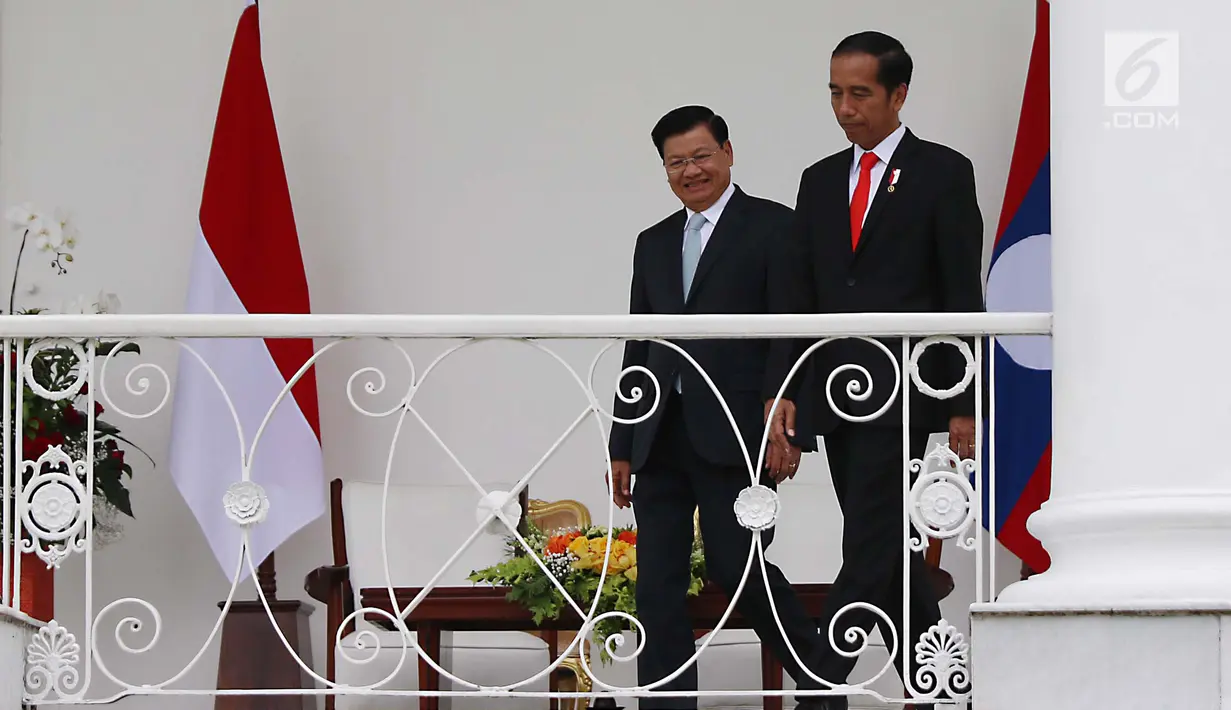 Presiden Jokowi dan PM Republik Demokratik Rakyat Laos Thongloun Sisoulith berjalan menuju beranda Istana Bogor, Kamis (12/8). Kunjungan kenegaraan PM Thongloun akan diakhiri dengan jamuan makan siang resmi. (Liputan6.com/Angga Yuniar)