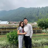 Memakai outfit senada tak hanya ditunjukkan saat momen-momen penting saja. Pelantun lagu duet 'Banyu Moto' ini juga tampil serasi saat di keseharian. Keduanya memakai baju bernuansa abu-abu saat sedang santai menikmati udara sejuk alam pedesaan. (Liputan6.com/IG/@nellakharisma)