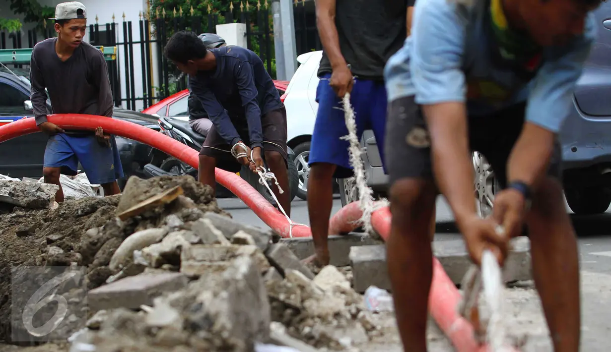 Buruh lepas mengerjakan proyek pemasangan instalasi listrik bawah tanah di Jakarta, Jumat (28/10). Upah layak para buruh lepas di DKI Jakarta masih terlihat kecil dan sangat memprihatinkan. (Liputan6.com/Angga Yuniar)