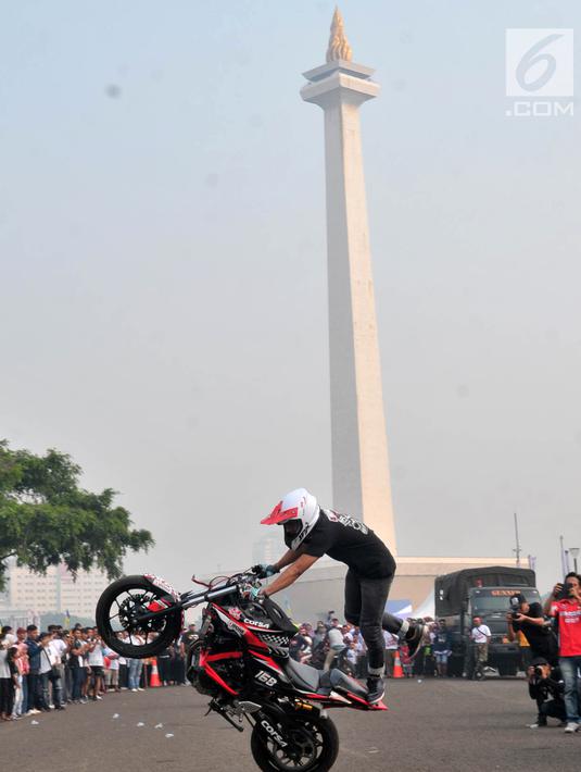 Freestyler melakukan atraksi freestyle sepeda motor saat memeriahkan Festival Damai Millenial Road Safety di Monas, Jakarta, Minggu (23/6/2019). Festival ini juga dimeriahkan oleh berbagai atraksi dan pertunjukan musik artis Tanah Air. (merdeka.com/Iqbal Nugroho)