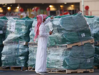 Seorang sukarelawan memeriksa paket bantuan yang disediakan oleh Arab Saudi sebelum dimuat ke dalam pesawat Kargo Saudi di bandara Internasional King Fahad di Riyadh pada 14 Oktober 2024. (Fayez Nureldine/AFP)