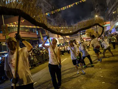 Peserta memainkan kesenian tradisional tari Naga Api Tai Hang di Hong Kong (3/10). Pertunjukan Naga Api ini melibatkan sekitar 300 orang. (AFP Photo/Anthony Wallace)