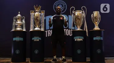 Legenda Manchester City, Shaun Wright-Phillips berpose dengan empat piala Man City—Premier League, Piala FA, Liga Champions, dan Piala Super UEFA—usai bertemu dengan sejumlah wartawan di Jakarta, Kamis (28/9/2023). (Liputan6.com/Helmi Fithriansyah)