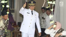 Gubernur DKI terpilih, Anies Baswedan mengacungkan jempol ke awak media di rumahnya kawasan Lebak Bulus, Jakarta, Senin (16/10). Berpakaian lengkap dinas Gubernur DKI, Anies bersiap pergi menuju Masjid Sunda Kelapa. (Liputan6.com/Immanuel Antonius)