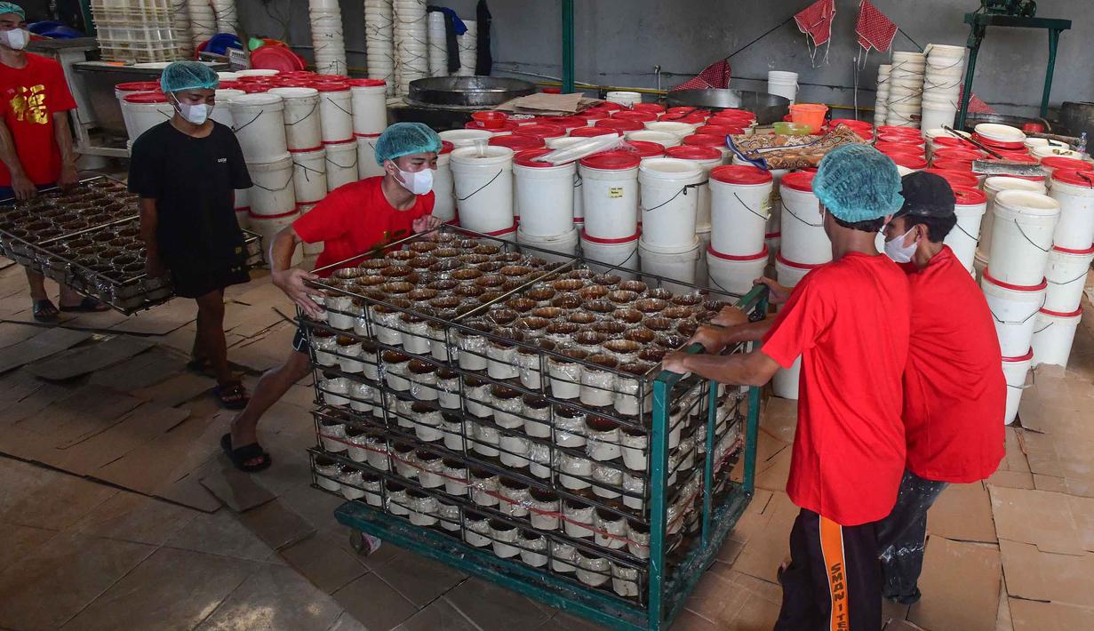 Untuk memenuhi permintaan jelang perayaan Imlek yang mencapai 2000 kue keranjang per hari, Pabrik Kue Hoki merekrut 50 tenaga tambahan yang diambil dari warga sekitar. Tampak dalam foto, pekerja menyelesaikan pengepakan kue keranjang di Pabrik Kue Hoki, kawasan Sawangan, Depok, Jawa Barat, Rabu (11/2/2025). (merdeka.com/Arie Basuki)