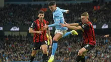 Phil Foden (Manchester City) berebut bola dengan Adrien Truffert dan Marcos Senesi (Bournemouth) dalam laga Liga Inggris di Etihad Stadium, 2 November 2025. (AP Photo/Ian Hodgson)