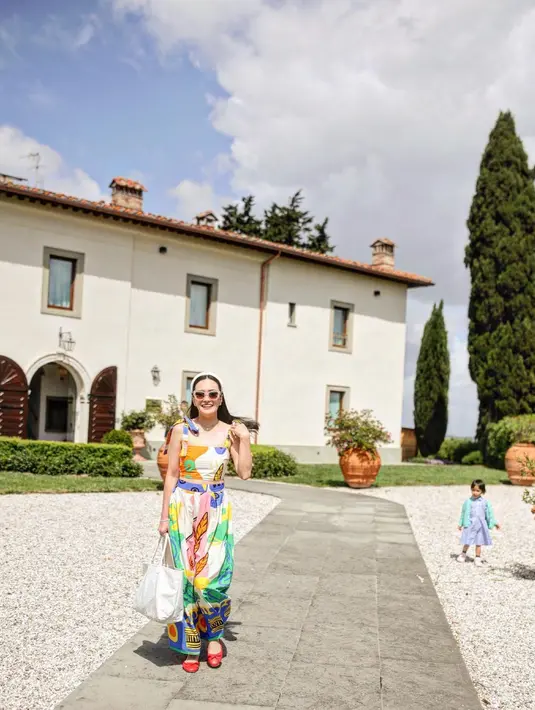 Shandy Aulia dengan outfit yang lebih colorful di foto ini. Ia mengenakan set atasan dan bawahan yang serasi. Atasan crop top bermotif abstrak berwarna-warni sesuai dengan celana panjangnya, nuansa kental musim panas. Foto: Instagram.