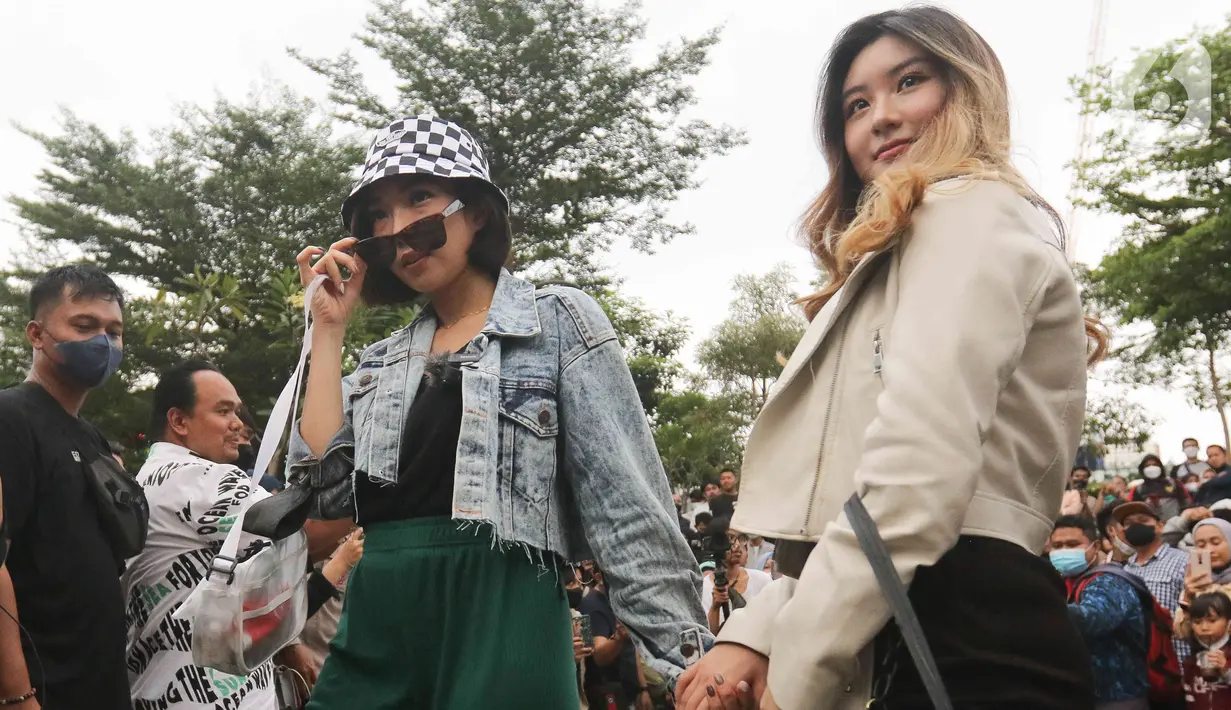 Penyanyi Gisella Anastasia berlenggak-lenggok di zebra cross Dukuh Atas saat meramaikan Citayam Fashion Week di kawasan SCBD (Sudirman Citayam Bojong Gede Dukuh Atas), Dukuh Atas, Jakarta Pusat, Senin (25/7/2022). Gisella tampil kasual dengan mengenakan jaket jeans, dalaman tanktop serta bawahan kulot hijau. (Liputan6.com/Herman Zakharia)