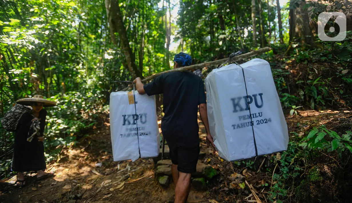 Warga Baduy Luar membawa kotak suara menuju TPS di kawasan Kadu Ketug 3, Leuwidamar, Lebak, Banten, Selasa (13/2/2024). (merdeka.com/Arie Basuki)