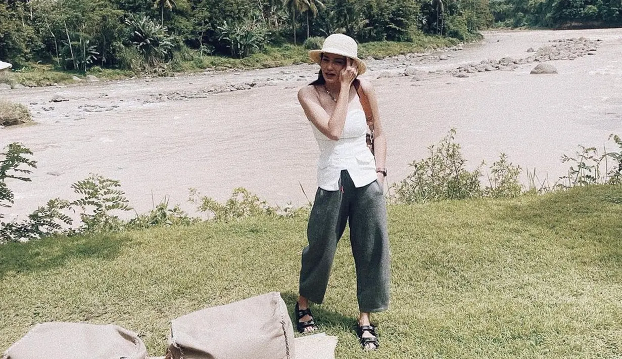Tampil dengan busana putih tanpa lengan, enzy terlihat memadukan penampilannya menggunakan celana berwarna abu-abu serta topi. Penampilan pemain Hello Ghost ini tampak begitu santai menggunakan sandal hitamnya. (Liputan6.com/IG/@enzystoria)
