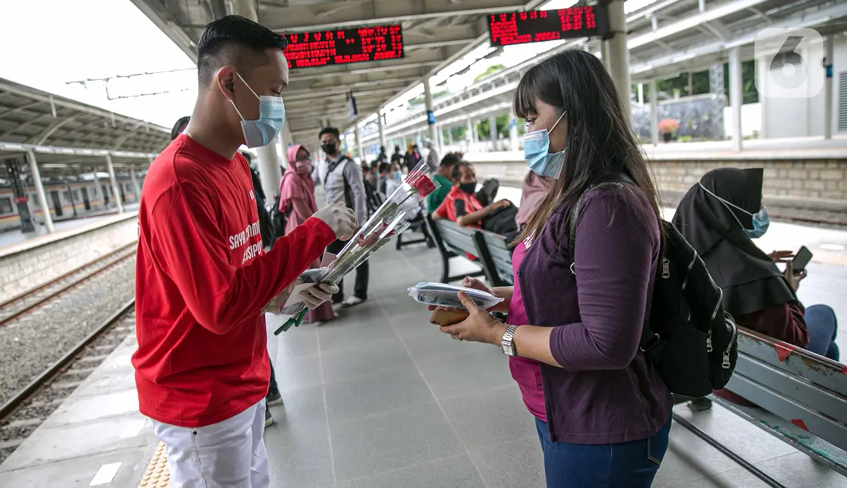 Petugas KAI Commuter (kiri) memberikan bunga dan healthy kit kepada perempuan pengguna KRL di Stasiun Jatinegara, Jakarta, Selasa (22/12/2020). Kegiatan tersebut dalam rangka memperingati Hari Ibu yang jatuh setiap tanggal 22 Desember. (Liputan6.com/Faizal Fanani)