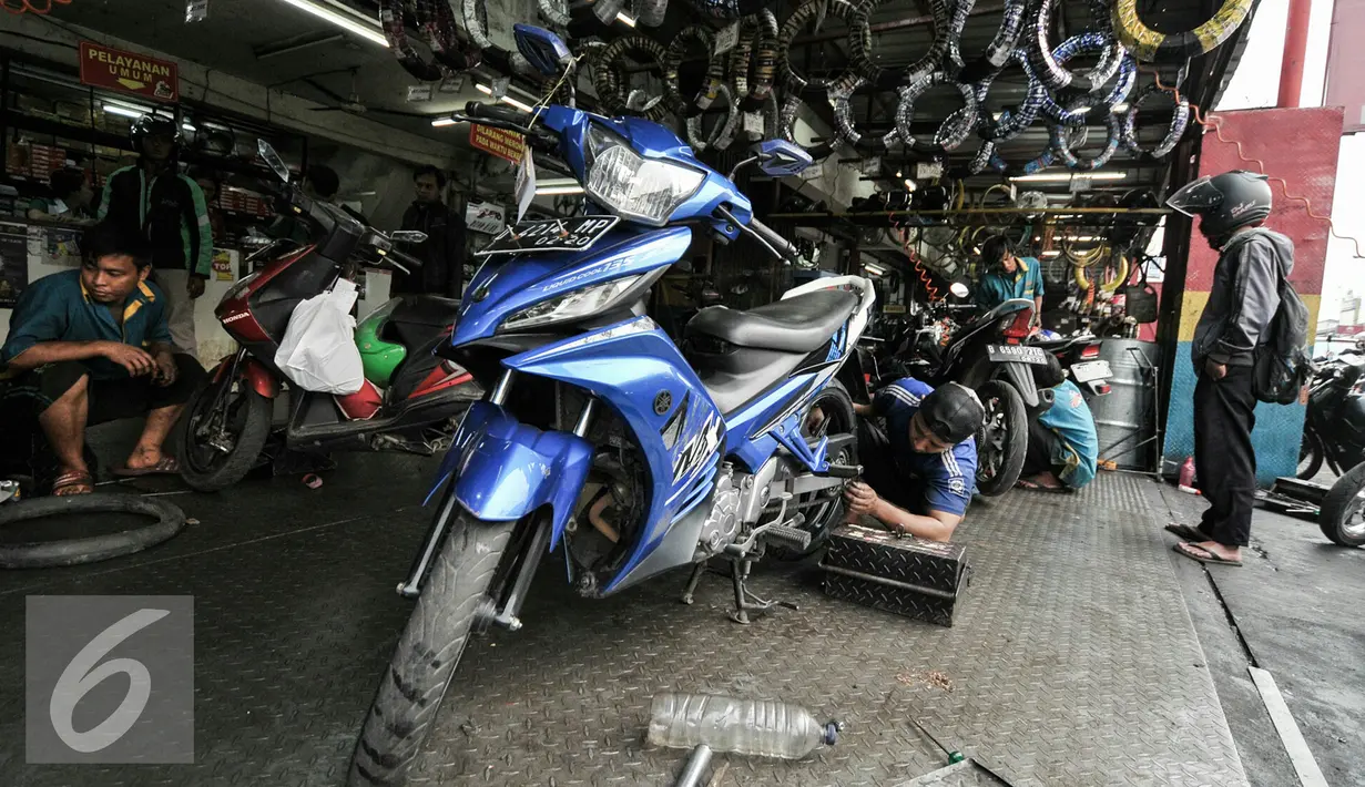 Seorang montir tengah memperbaiki mesin motor di kawasan Pasar Minggu, Jakarta, Kamis (30/6). Jelang mudik Lebaran menjadi rezeki tersendiri untuk pekerja jasa servis motor. (Liputan6.com/Yoppy Renato)