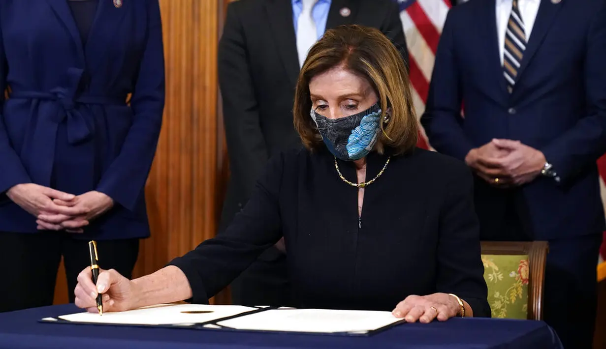 Ketua DPR Nancy Pelosi menandatangani dokumen pemakzulan Presiden Donald Trump di Capitol Hill, Washington, Amerika Serikat, Rabu (13/1/2021). Ada 10 anggota Partai Republik yang ikut mendukung pemakzulan Donald Trump. (AP Photo/Alex Brandon)