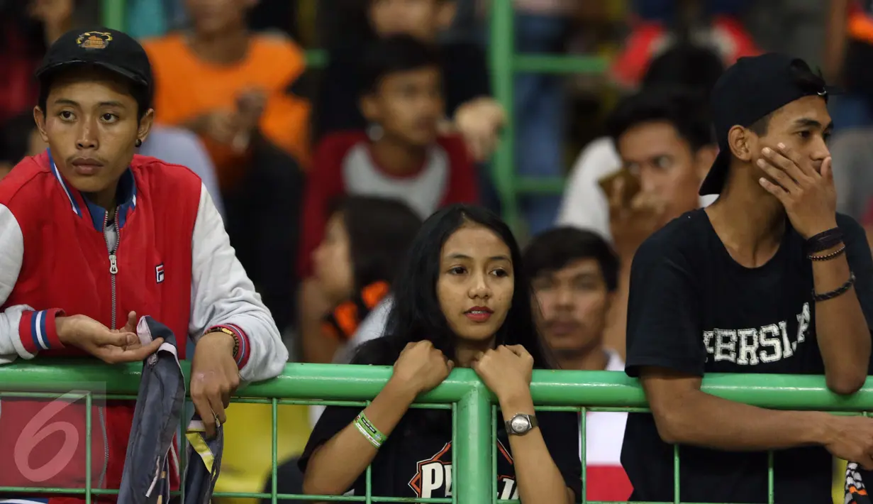 Suporter Persija termangu usai menyaksikan timnya berlaga melawan Madura United FC pada lanjutan Liga 1 di Stadion Patriot Candrabhaga, Bekasi, Kamis (4/5). Persija kalah 0-1. (Liputan6.com/Helmi Fithriansyah)